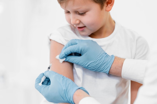 Close-up kleine jongen die vaccin krijgt