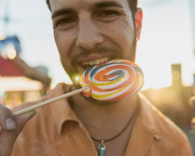 Close-up knappe kerel met kleurrijke lolly