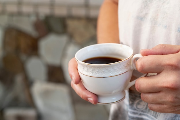 Close-up kopje koffie gehouden door persoon