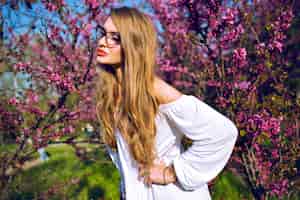 Gratis foto close-up lente zomer portret van prachtige jonge vrouw met natuurlijke verbazingwekkende lange haren en schoonheid gezicht, heldere bril, zonnige kleuren.