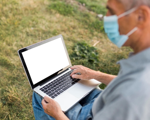 Close-up man met laptop en masker