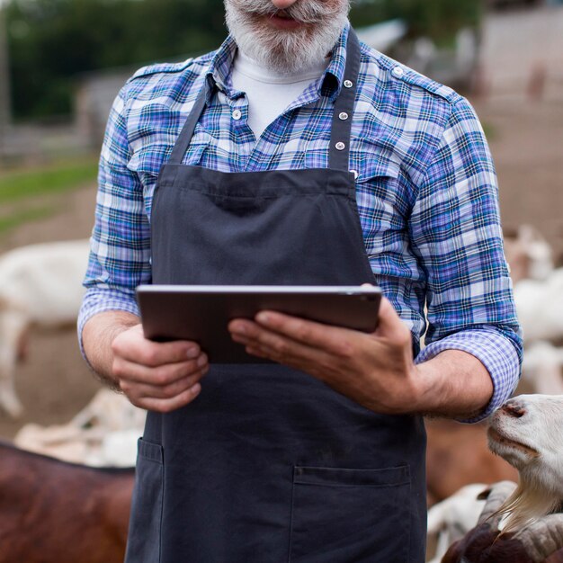 Close-up man op boerderij kijken op tablet