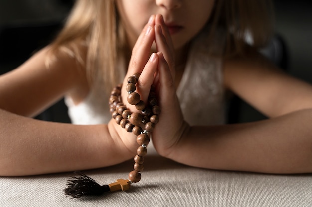 Close-up meisje bidden met crucifix