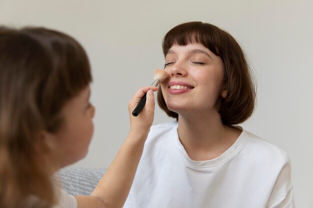 Close-up meisje make-up op moeder zetten