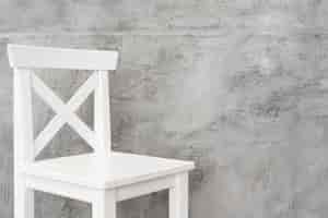 Gratis foto close-up minimalistische witte kruk met betonnen panelen