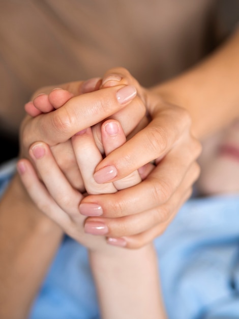 Close-up moeder en zoon hand in hand