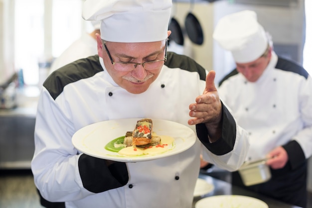 Close-up op chef-kok die het gerecht ruikt na het koken