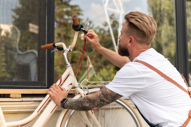 Gratis foto close-up op jonge man aan het werk op een fiets