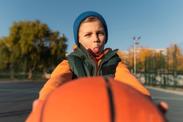 Gratis foto close-up op kleine jongen die basketbal speelt