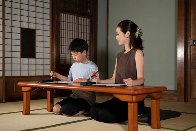 Close-up op leerlingen die Japanse kalligrafie doen, genaamd shodo