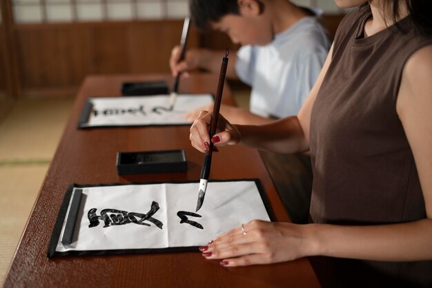 Close-up op leerlingen die Japanse kalligrafie doen, genaamd shodo