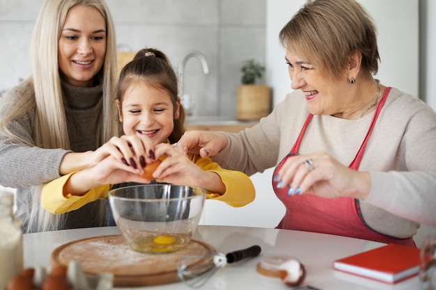 Gratis foto close-up op meisje koken met haar moeder en grootmoeder
