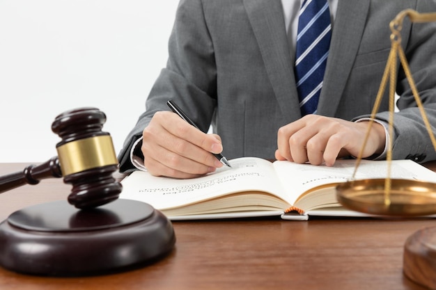 Close-up opname van een persoon die in een boek schrijft met een hamer op de tafel