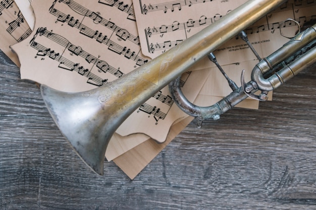 Gratis foto close-up oude trompet op bladmuziek