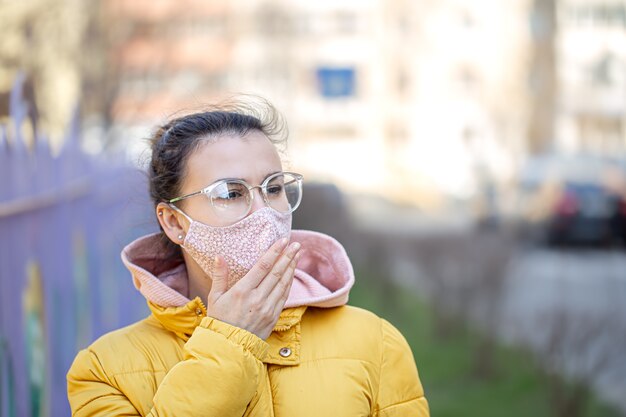 Close-up portret jonge vrouw in een masker tijdens het pandemische coronavirus.