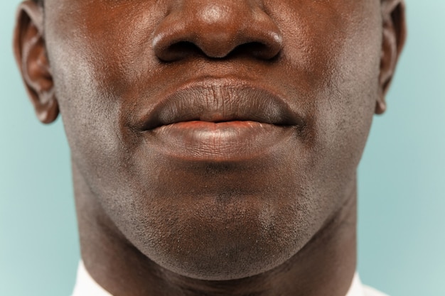 Close-up portret van de jonge man op blauwe studio muur