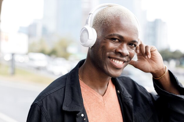 close-up portret van een knappe lachende zwarte man met koptelefoon buitenshuis