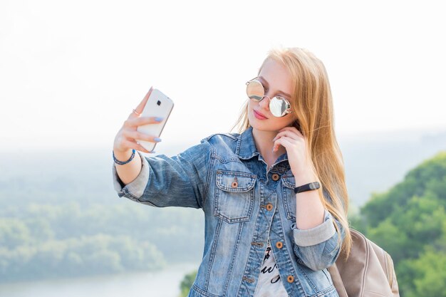 Close-up portret van een meisje dat selfies neemt op een smartphone in het natuurpark