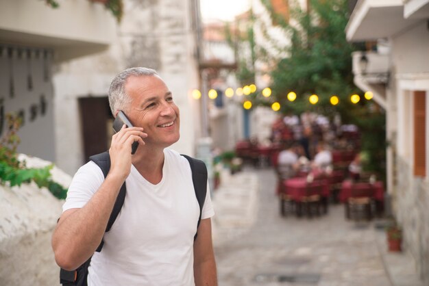 Close-up portret van een volwassen zakenman praten op zijn mobiele telefoon buitenshuis.