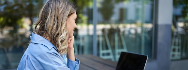 Gratis foto close-up portret van een vrouwelijke student die online cursuslessen bijwoont terwijl hij buiten in de frisse lucht zit