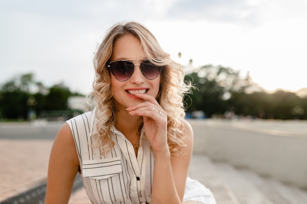 Close-up portret van jonge aantrekkelijke stijlvolle blonde vrouw in stad straat in zomer mode stijl jurk dragen van een zonnebril