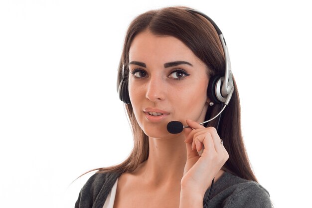 Close-up portret van jonge call center operator met koptelefoon geïsoleerd op een witte muur in de studio