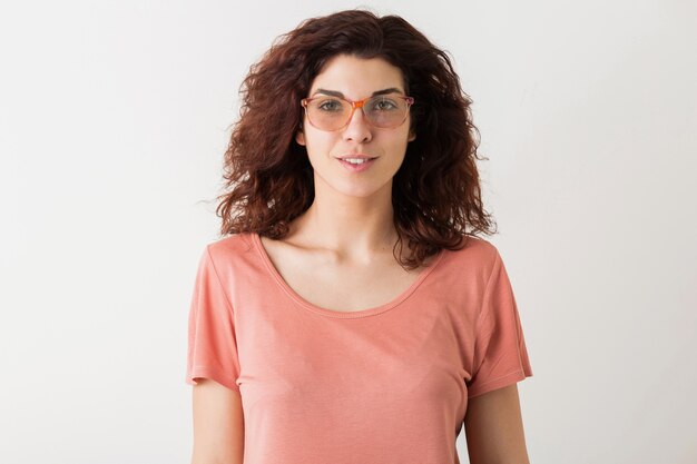 Close-up portret van jonge natuurlijke hipster mooie vrouw met krullend kapsel in roze shirt poseren met bril geïsoleerd op witte studio achtergrond