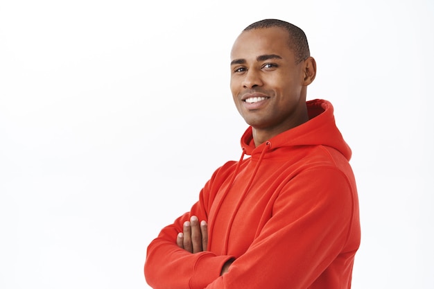 Close-up portret van jonge succesvolle Afro-Amerikaanse volwassen man in rode hoodie