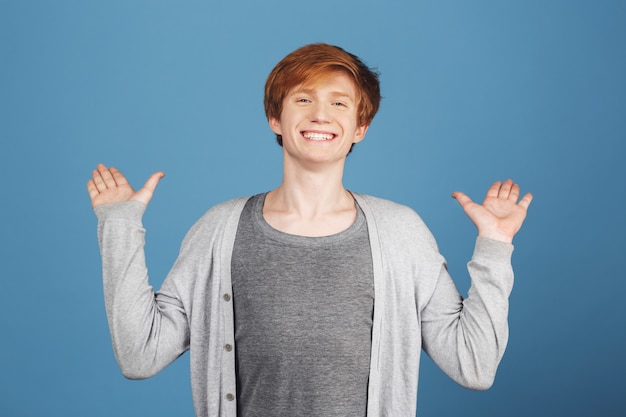 Close-up portret van jonge vrolijke gelukkig mooie roodharige student in stijlvolle casual outfit handen met opgewonden expressie verspreiden, zien van beste vriend na een lange tijd.