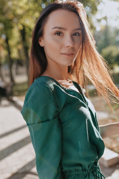 Close-up portret van mooie blanke vrouw met glimlach kijkt naar camera Donkerharige vrouw in groene blouse Vrouwen lente mode concept