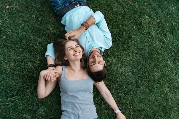Close-up portret van zorgeloos paar liggend op gras samen verliefd