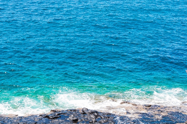Close-up rotsachtige kust met kristallijn water