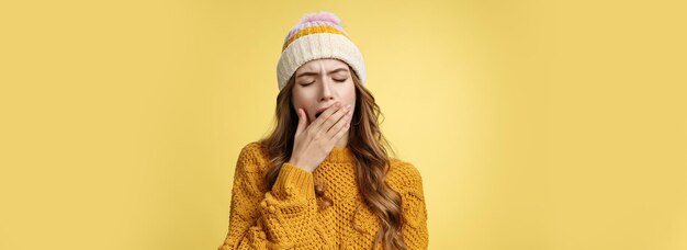 Gratis foto close-up shot moe gapende schattige uitgeputte europese vrouw met hoed trui deksel geopend mondgevoel