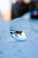 Gratis foto close-up shot of een druppel water op de besneeuwde grond als gevolg van een deel van de stad