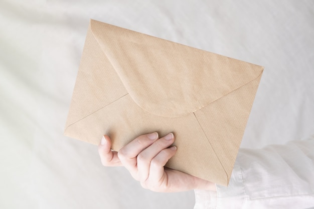 Gratis foto close-up shot van de hand van een persoon die een envelop vasthoudt