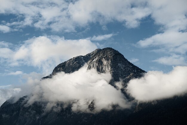 Close-up shot van een bergtop gedeeltelijk bedekt door wolken