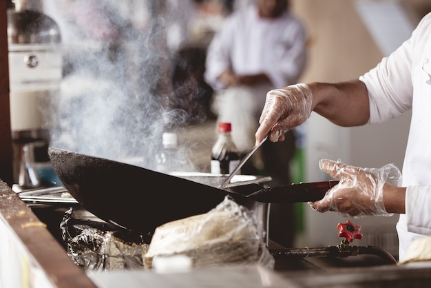 Close-up shot van een chef-kok koken met een onscherpe achtergrond