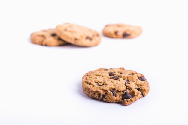 Close-up shot van een chocoladeschilferkoekje met koekjes op een vage witte achtergrond