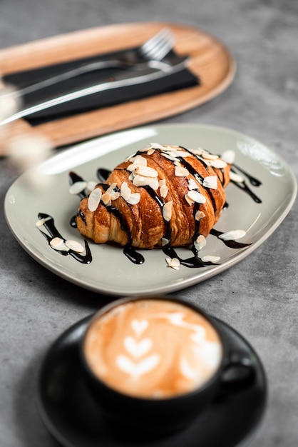 Close-up shot van een croissant op een bord bedekt met chocolade in een café