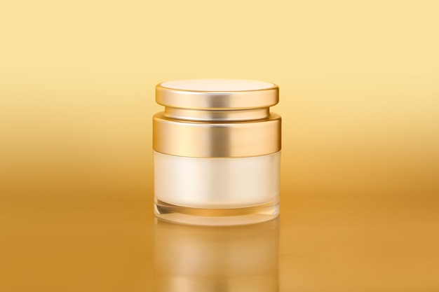 Close-up shot van een elegante gouden huidverzorging container op een gouden achtergrond