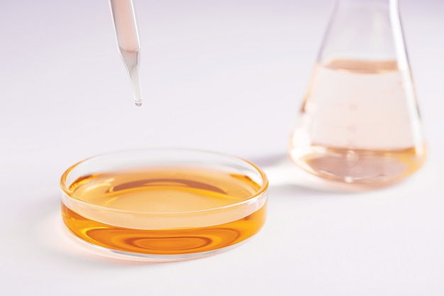 Close-up shot van een glazen schaal met gele vloeistof en een druppelaar in een lab