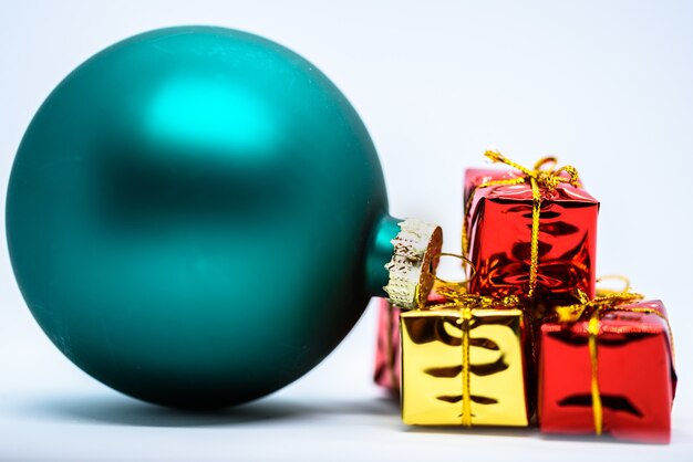 Gratis foto close-up shot van een groen kerstboom ornament in de buurt van de kleurrijke cadeautjes