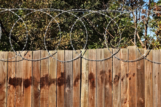 Gratis foto close-up shot van een houten hek met prikkeldraad