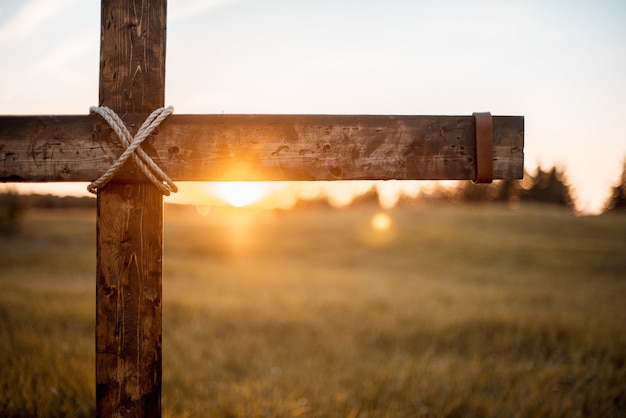 Close-up shot van een houten kruis met de zon schijnt
