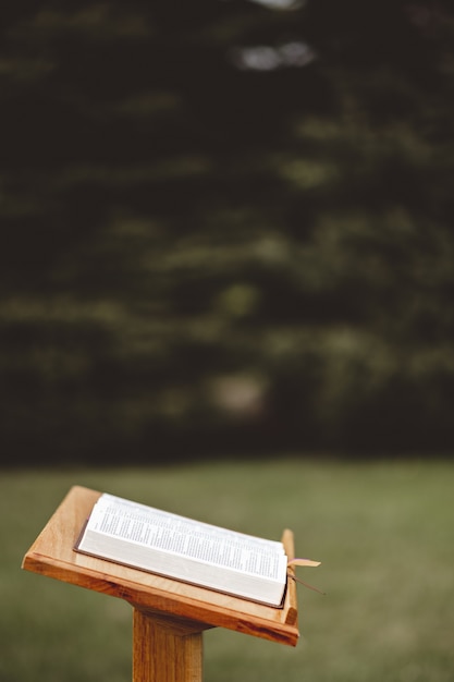 Gratis foto close-up shot van een houten toespraak staan met een geopend boek