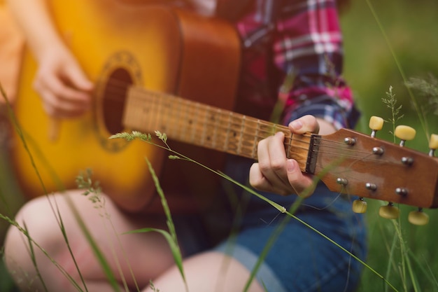 Gratis foto close-up shot van een jong meisje dat gitaar speelt