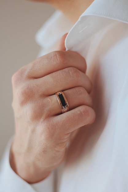 Close-up shot van een man in een formele outfit met een gouden ring