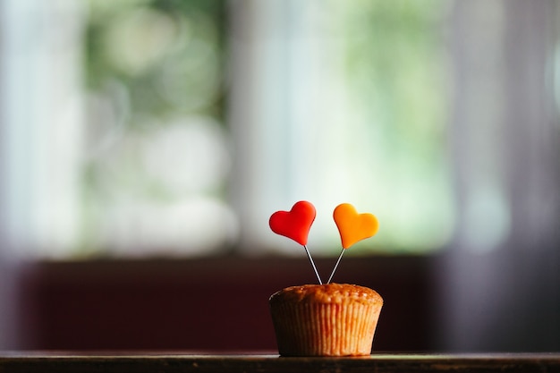 Close-up shot van een muffin met kleurrijke hartjes erop