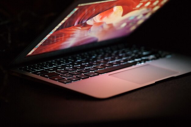 Close-up shot van een opengeklapte laptop op een donker oppervlak werk vanuit huis concept