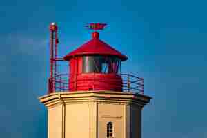 Gratis foto close-up shot van een rode en witte toren achter een blauwe hemel